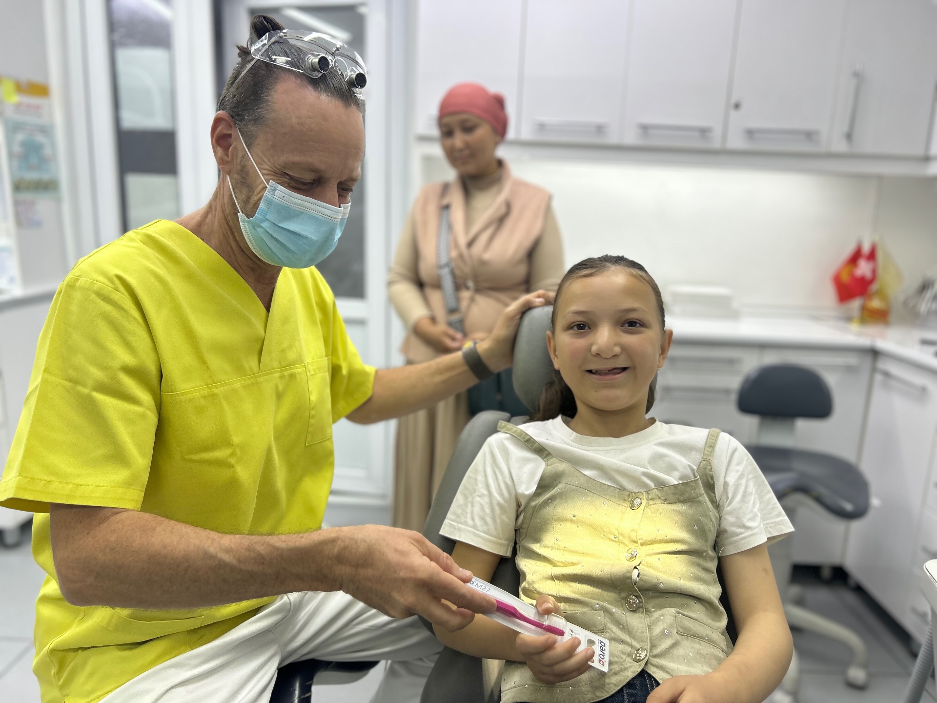 Dr. Marcel Frei übergibt einer Patientin in Kirgistan eine Zahnbürste